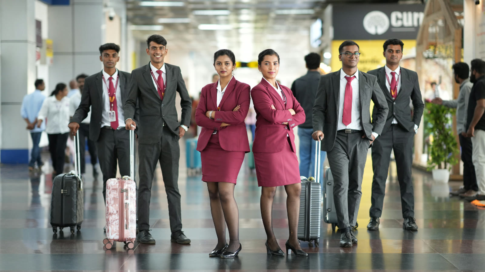 Six Brandcrew students in uniform standing together in an Airport terminal