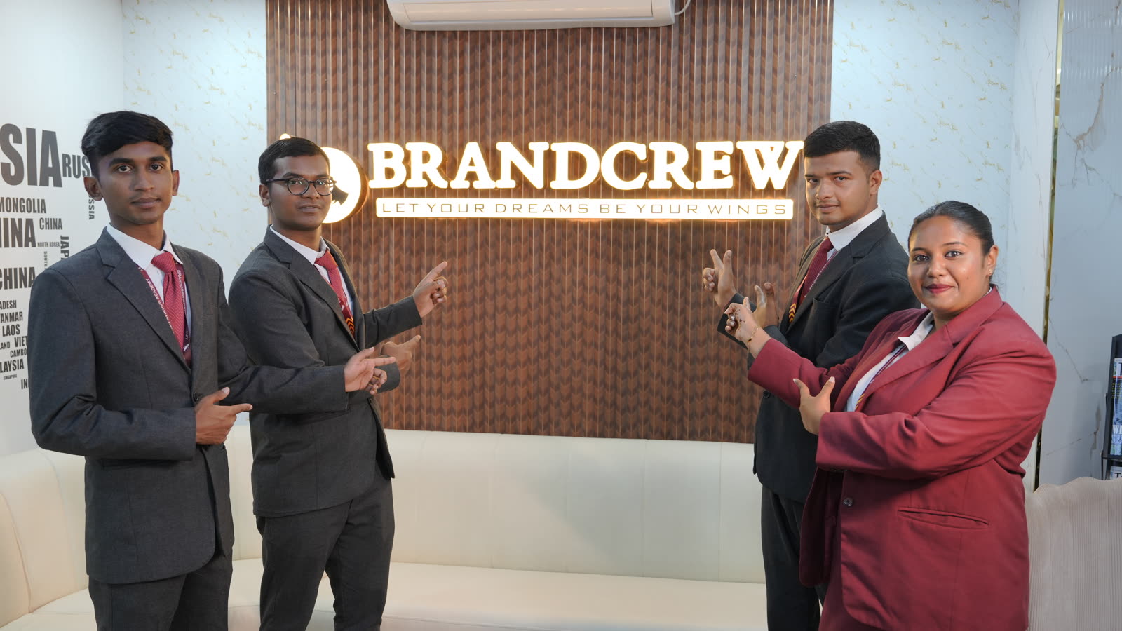 Students in uniform welcoming visitors beside the Brandcrew reception sign