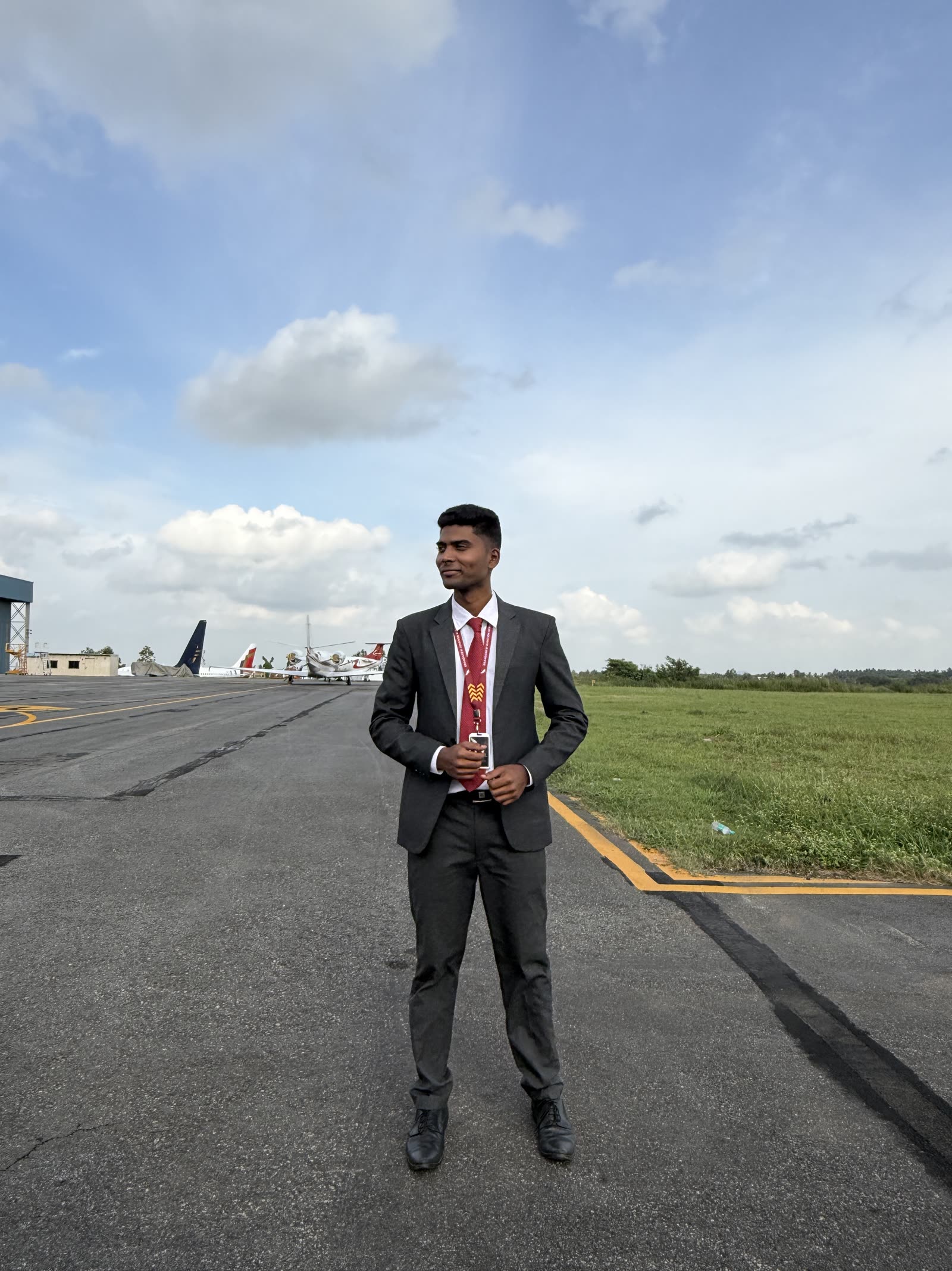 A student in a grey suit standing on the taxiway