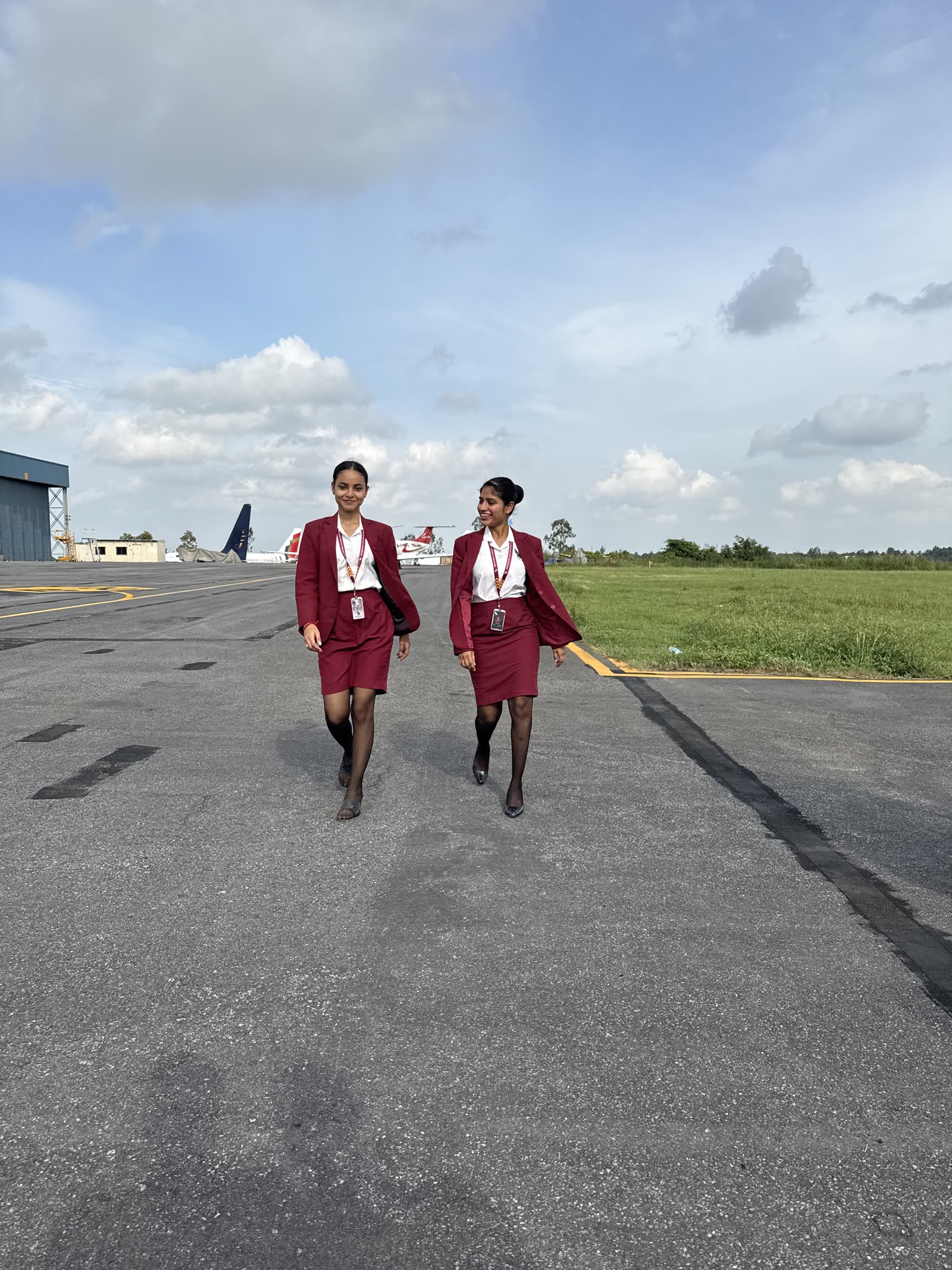 Two trainees walking down the taxiway mid-conversation