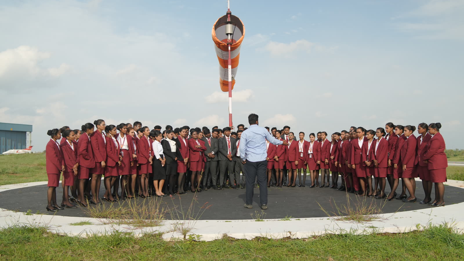 Students circled around the airfield windsock with their instructor