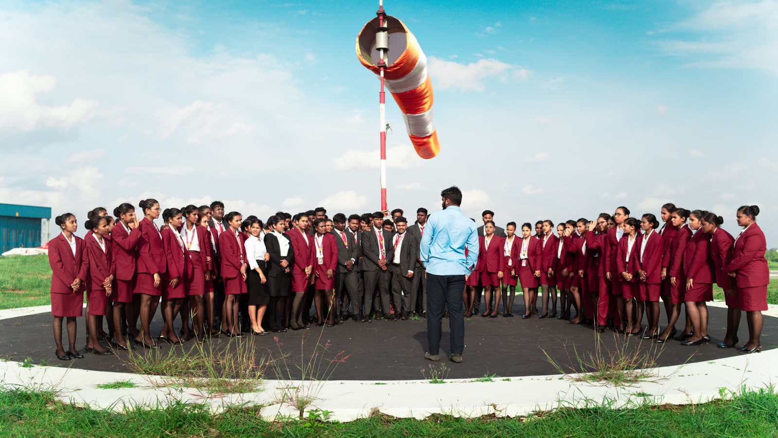 The full cohort circled around the windsock at TAAL airfield during outdoor ground school
